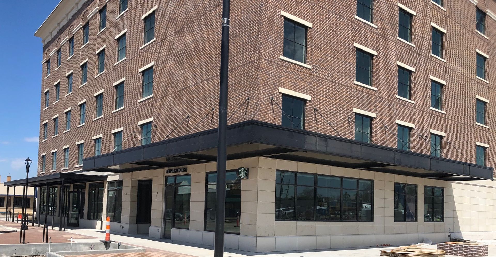 A large brick building with a lot of windows is under construction.