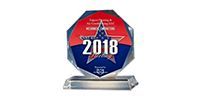 An octagonal 2018 award trophy with a red, white, and blue star design on a clear glass stand.