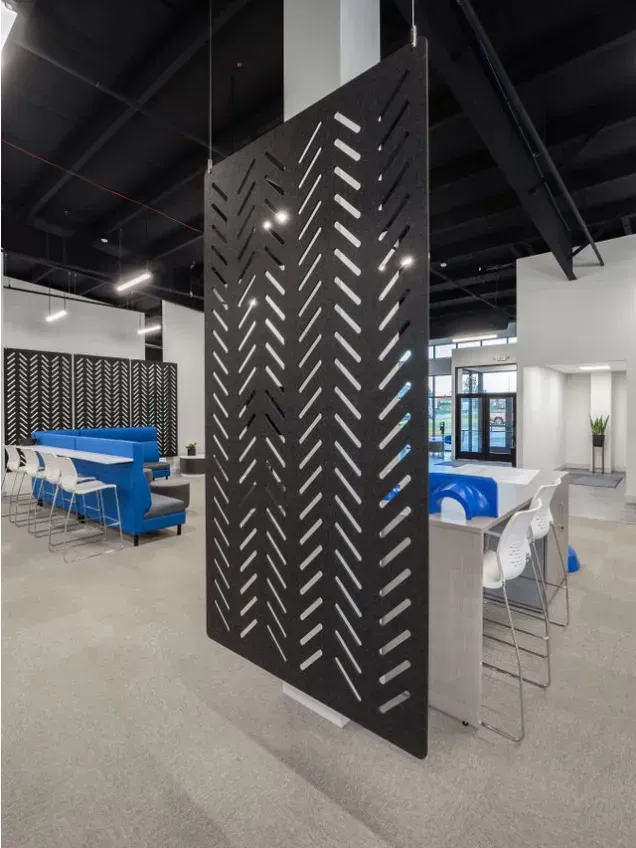 Black patterned room divider in an open office space.