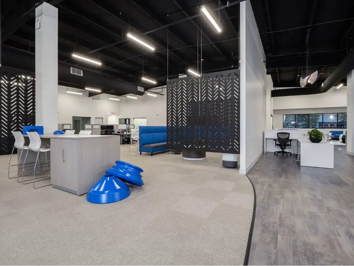 Modern office interior with white walls, black ceiling, and blue accents.
