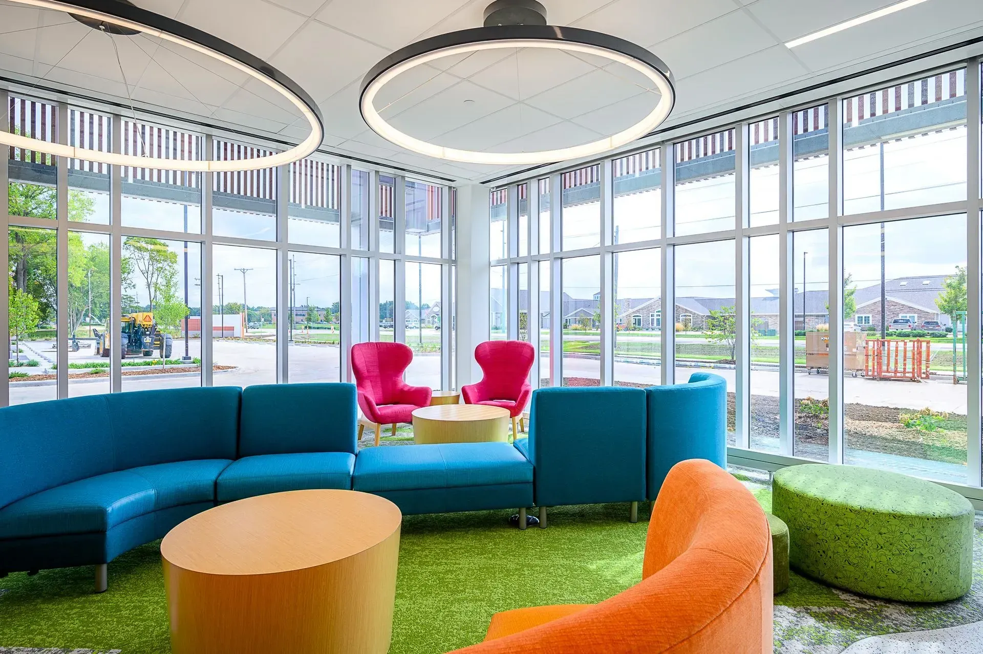 Brightly colored seating in a modern lounge area with large windows overlooking the outdoors.