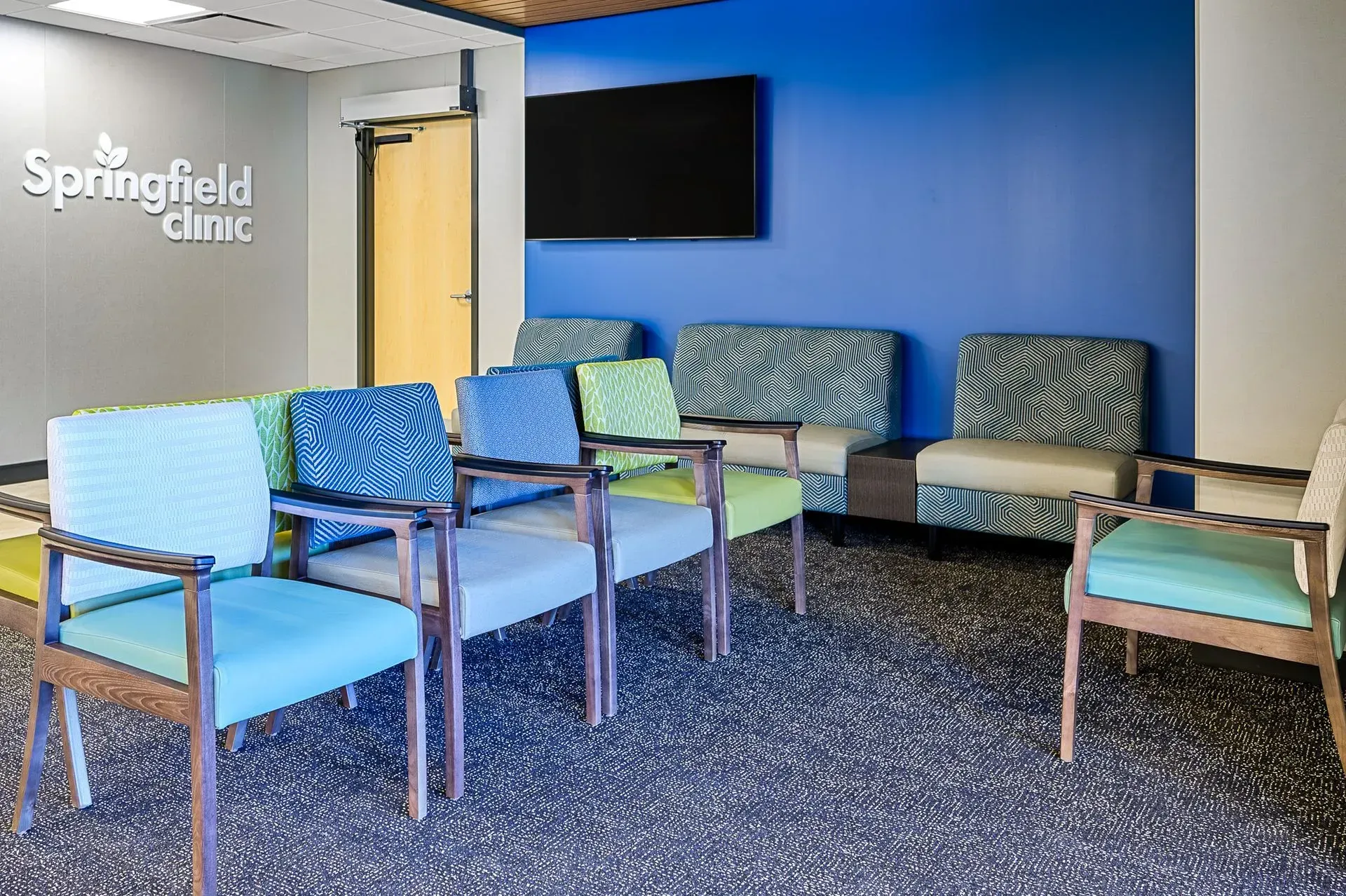 Waiting room at Springfield Clinic with patterned chairs and blue accent wall.