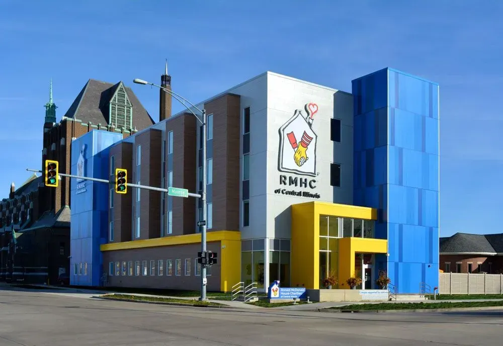 Modern, colorful building of the Ronald McDonald House Charities (RMHC) next to a church.