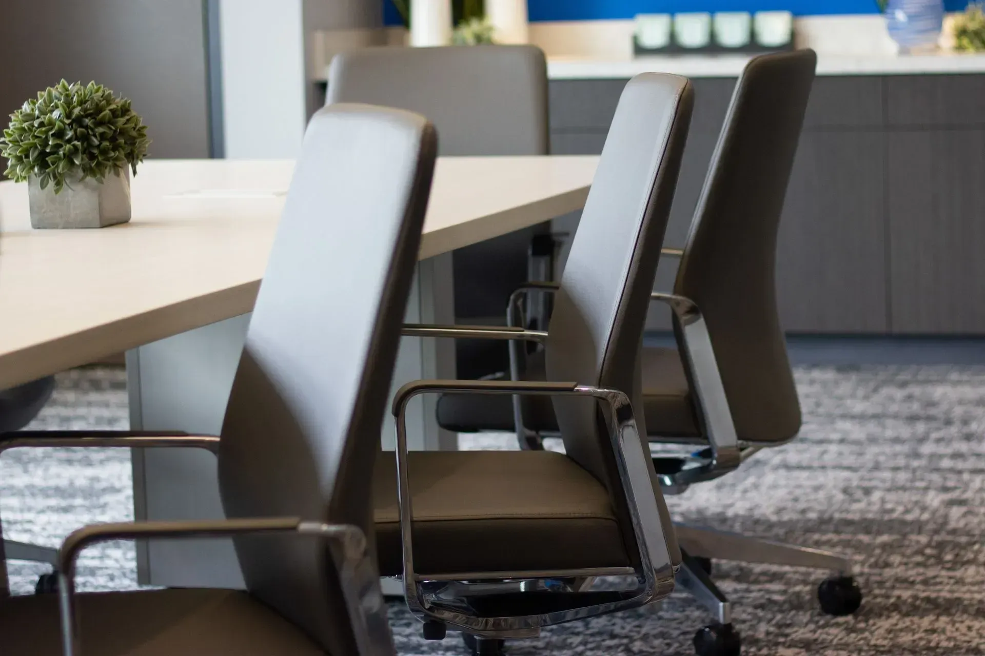 Gray office chairs at a white table in a modern office space.