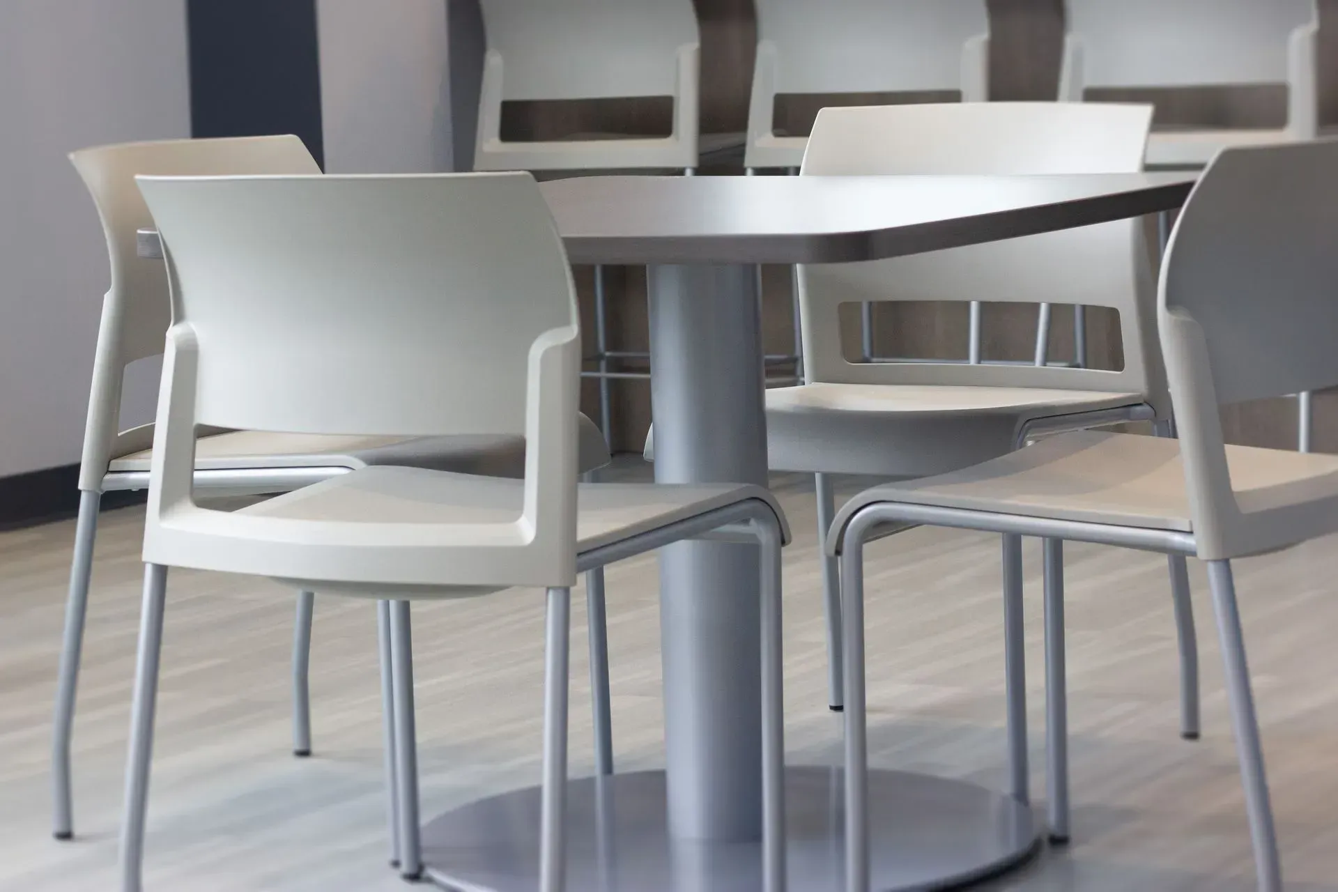 Round table with light gray chairs in a modern, well-lit room.