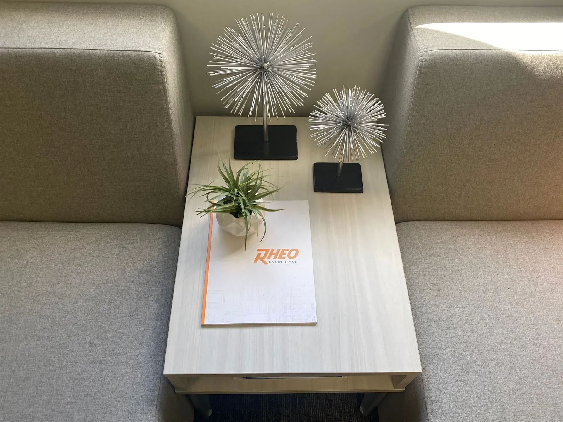 Small table between two couches with decorations, including metal spheres and a plant. A menu rests on the table.