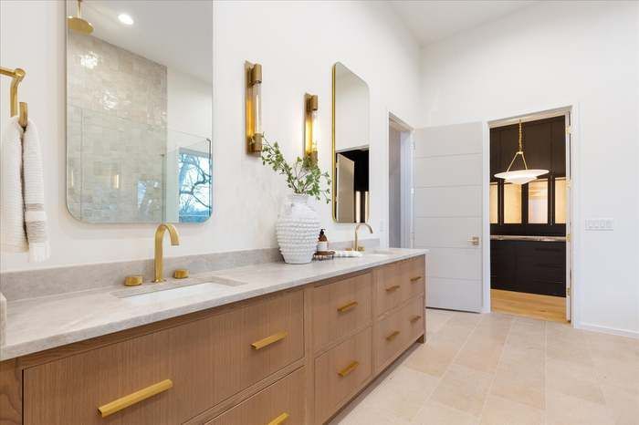 A bathroom with two sinks , a mirror , and a large vanity.