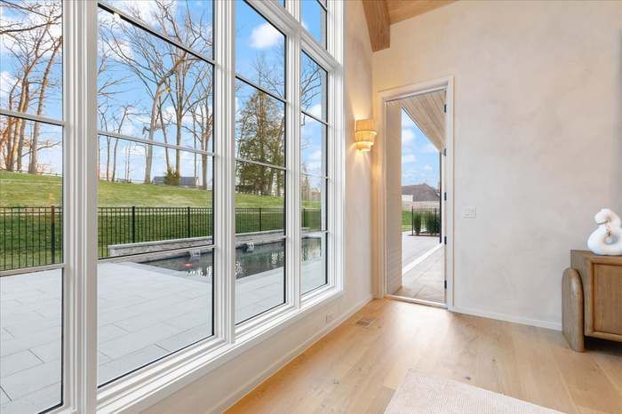 A living room with a lot of windows and a door leading to a patio.