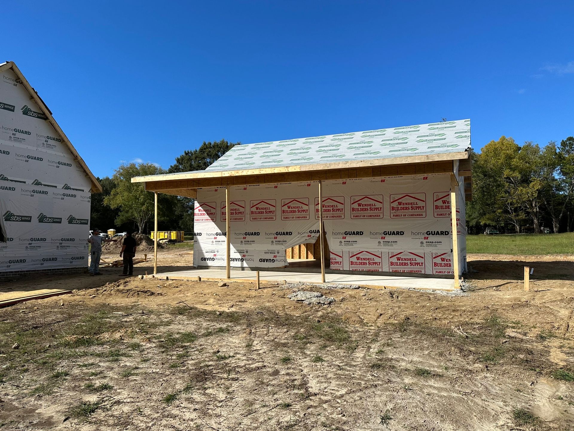 White colonial house with black shutters, large columns, and a brick walkway.