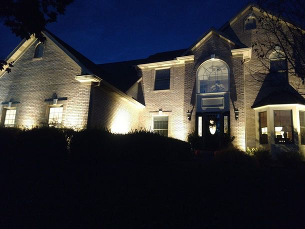Large brick house lit at night against a dark sky