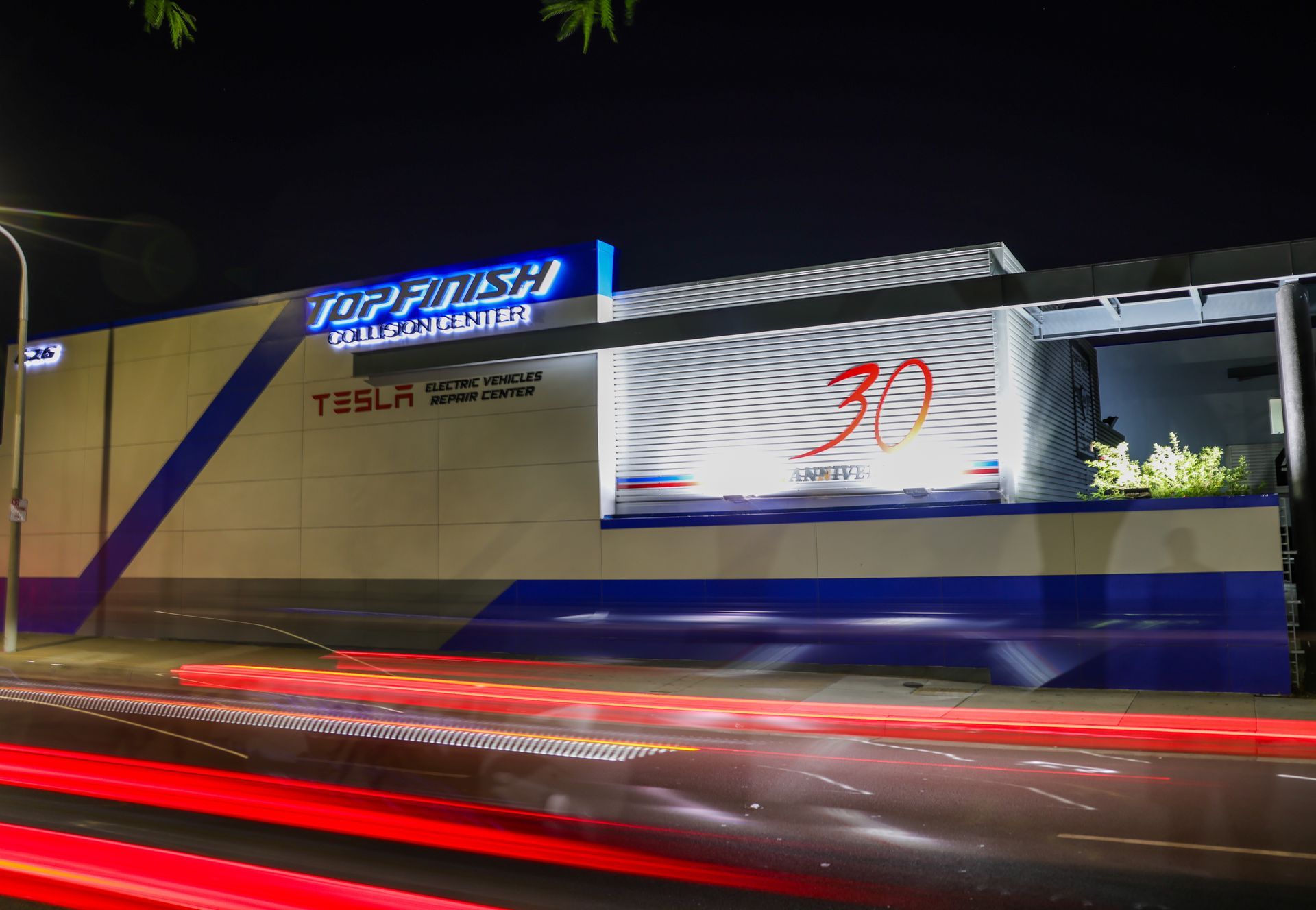 Night view of a Tesla auto body shop, 