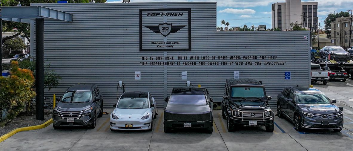 Cars parked in front of a building with the name