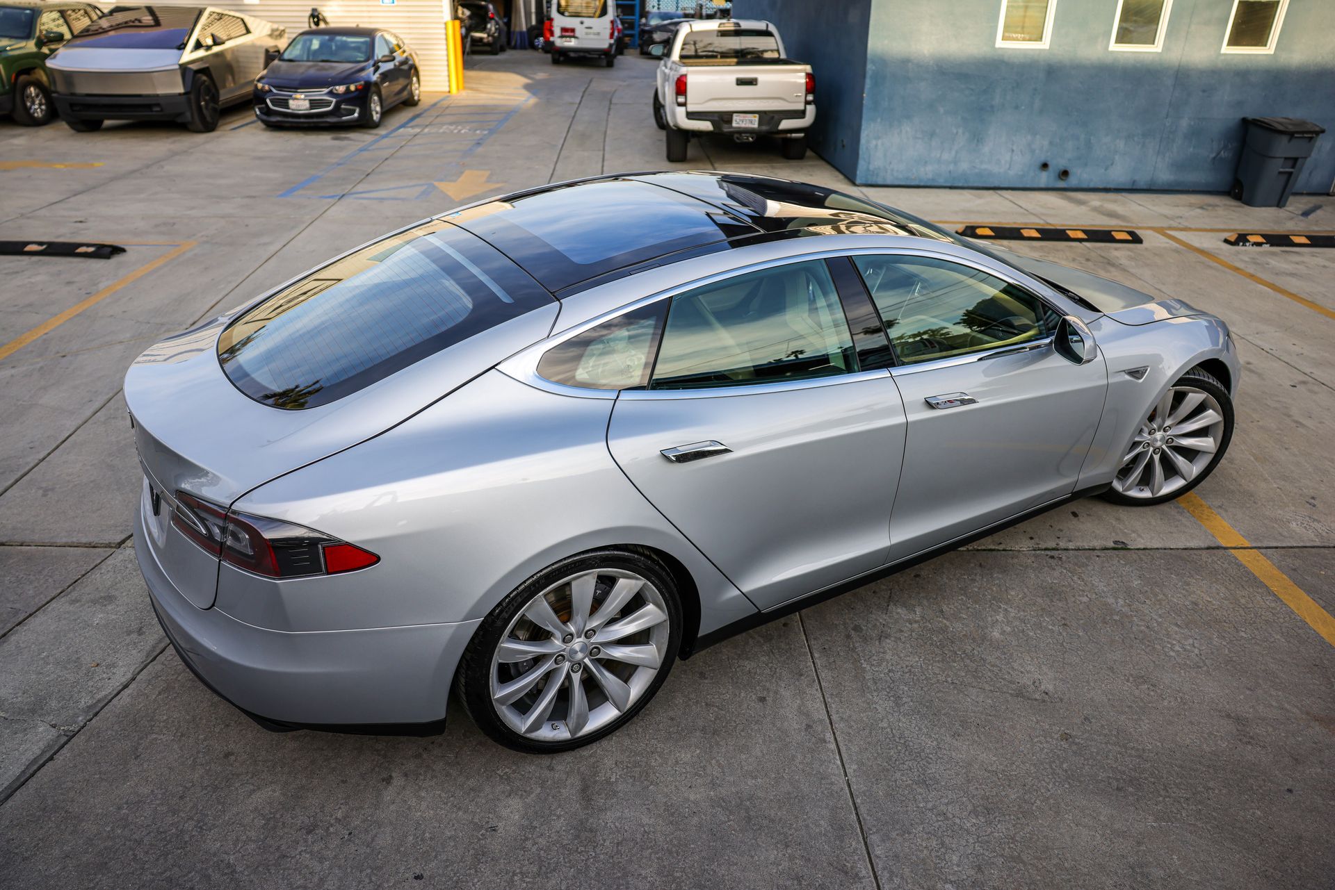 A black car with a license plate that says texas on it is parked in a parking lot.