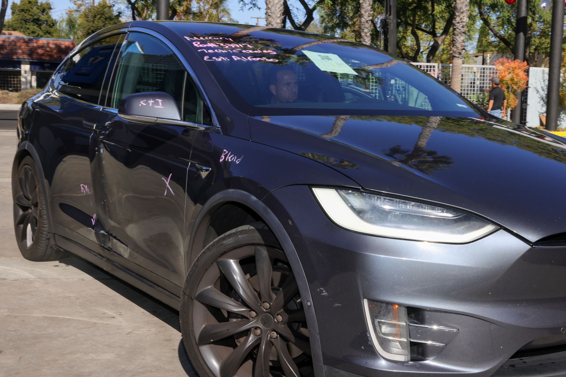 The back of a black mercedes benz glc 300 is parked in a parking lot.
