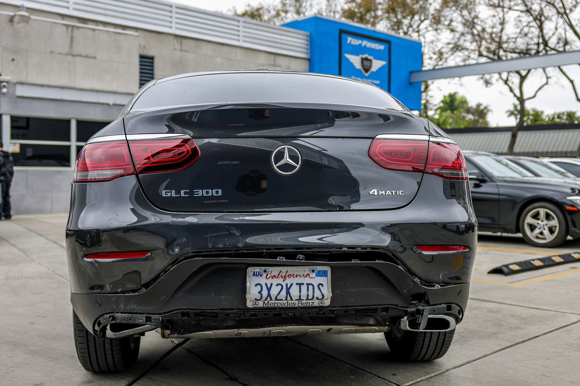 A black tesla model x is parked in a parking lot.