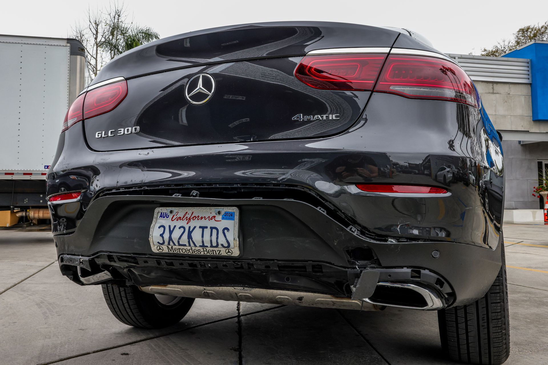 A man wearing a mask is spray painting a car.