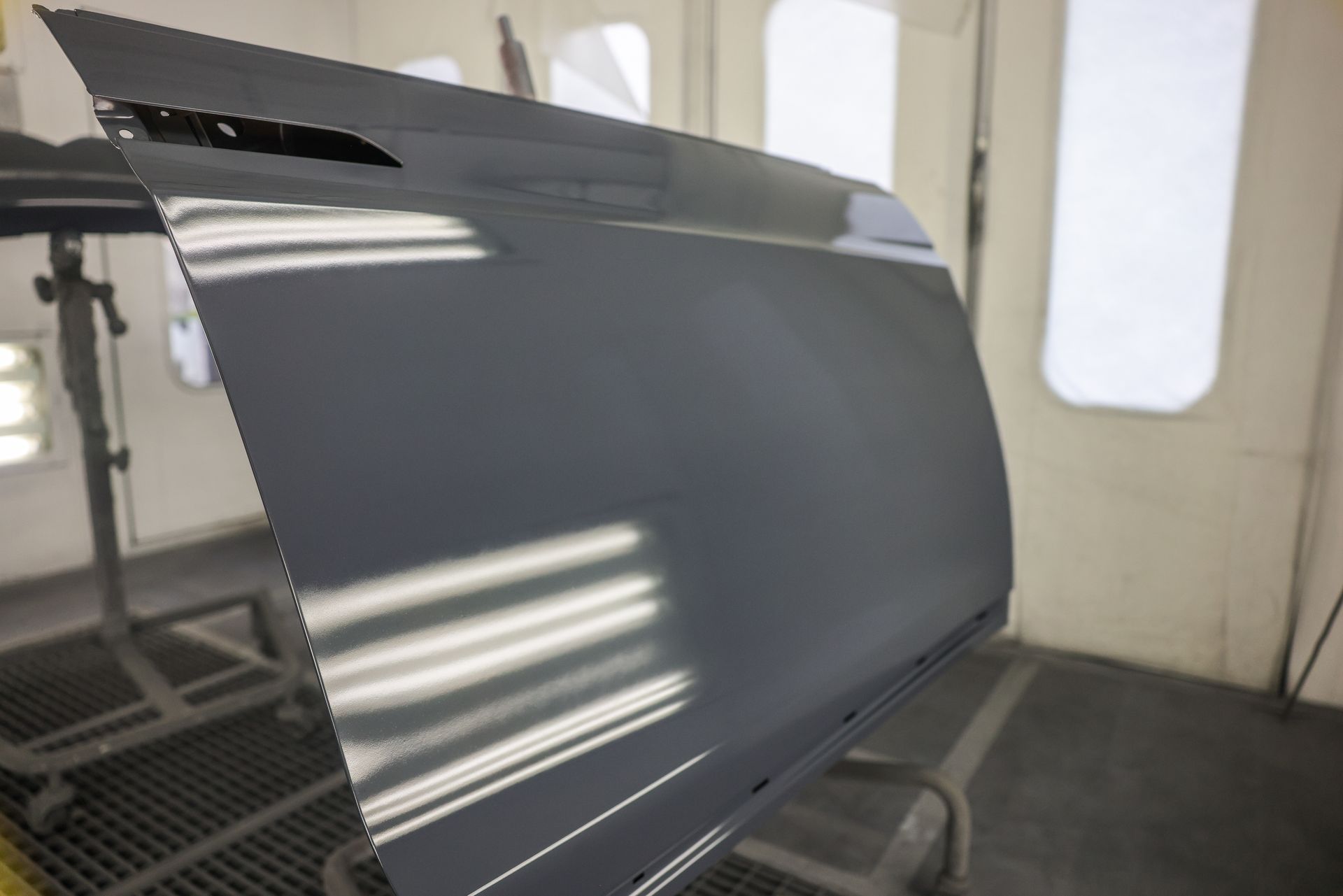 A man wearing a mask and gloves is painting a car.