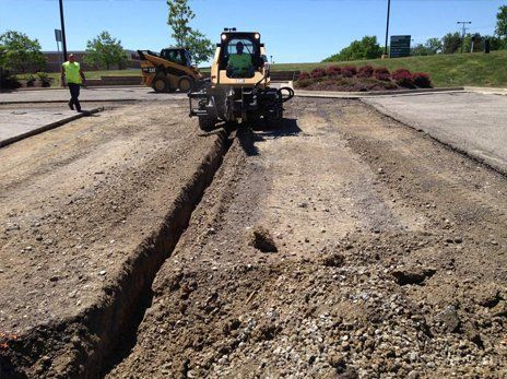 Restaurant with a red and gray facade, large parking lot, and American flag under a blue sky.