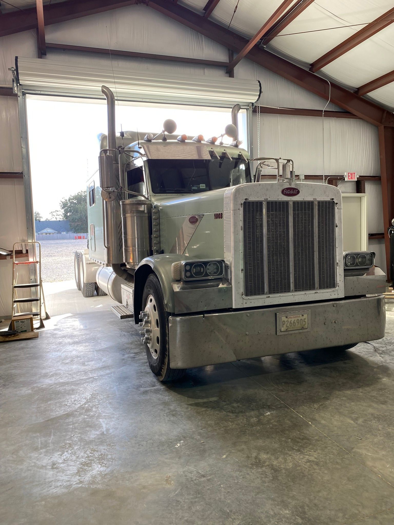 A Peterbilt semi truck is parked in a garage.