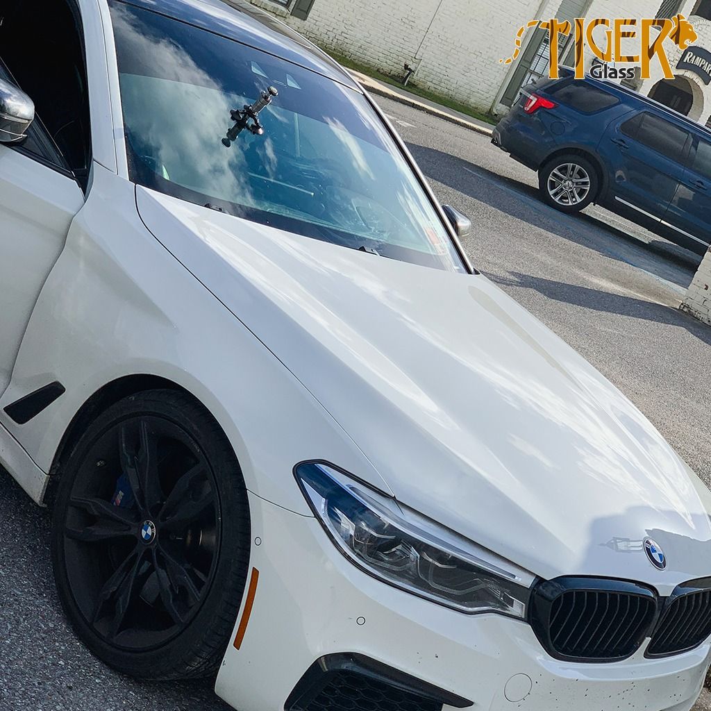 A white bmw is parked on the side of the road