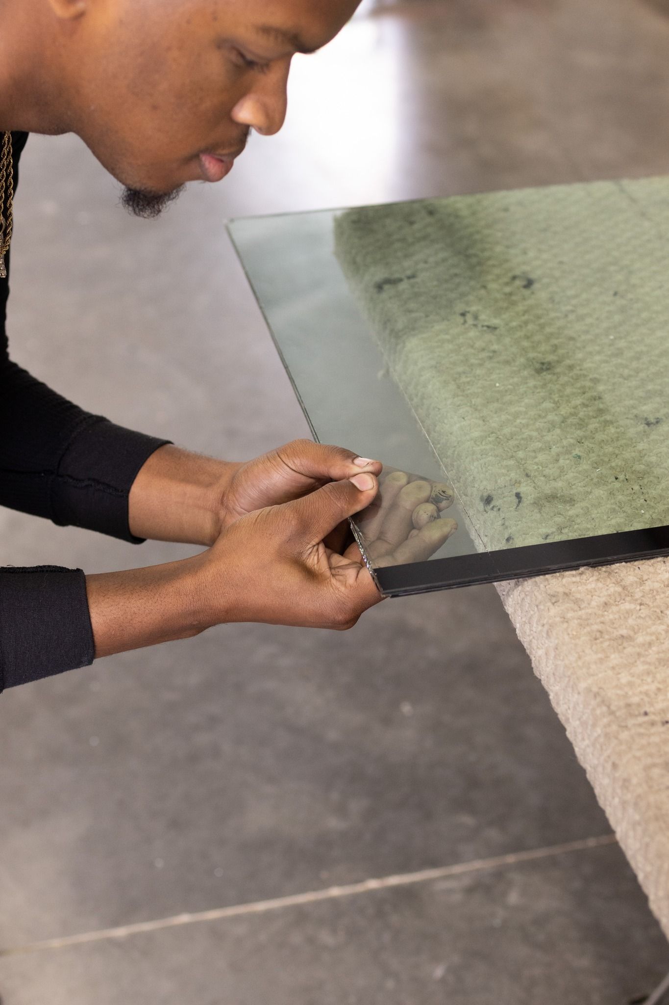 A man is cutting a piece of glass with a saw