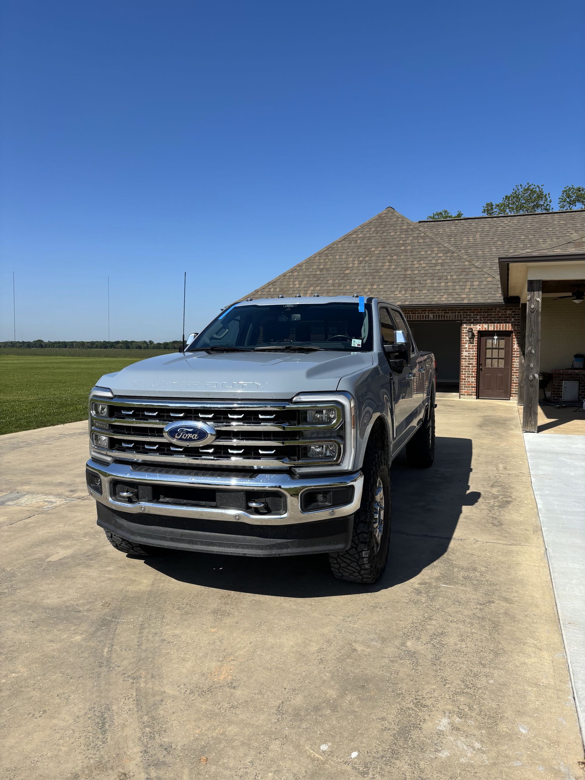 A silver ford truck is parked in a driveway in front of a house