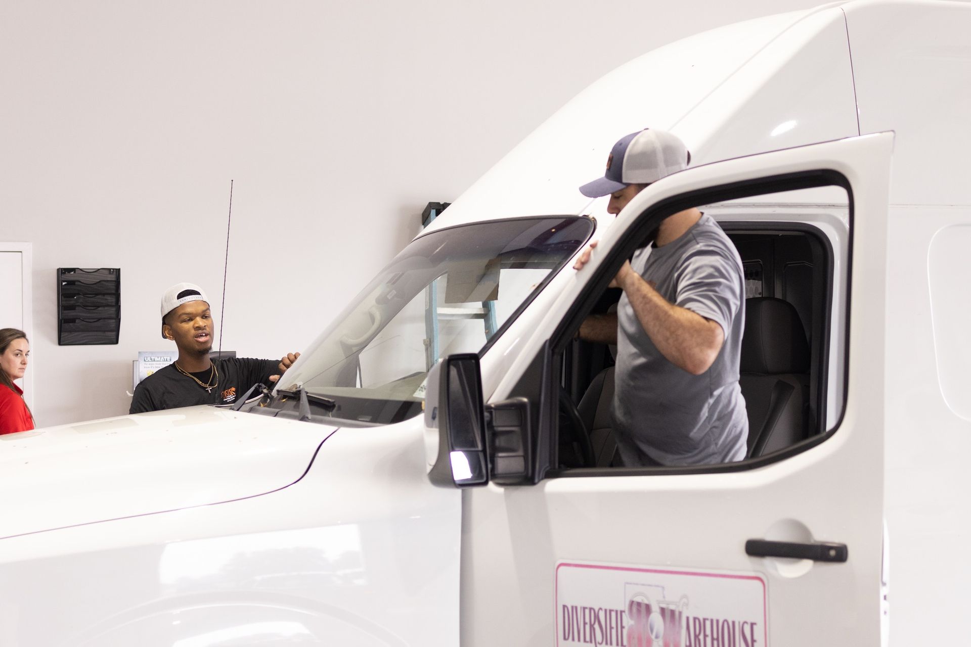 A man is sitting in the driver's seat of a white van