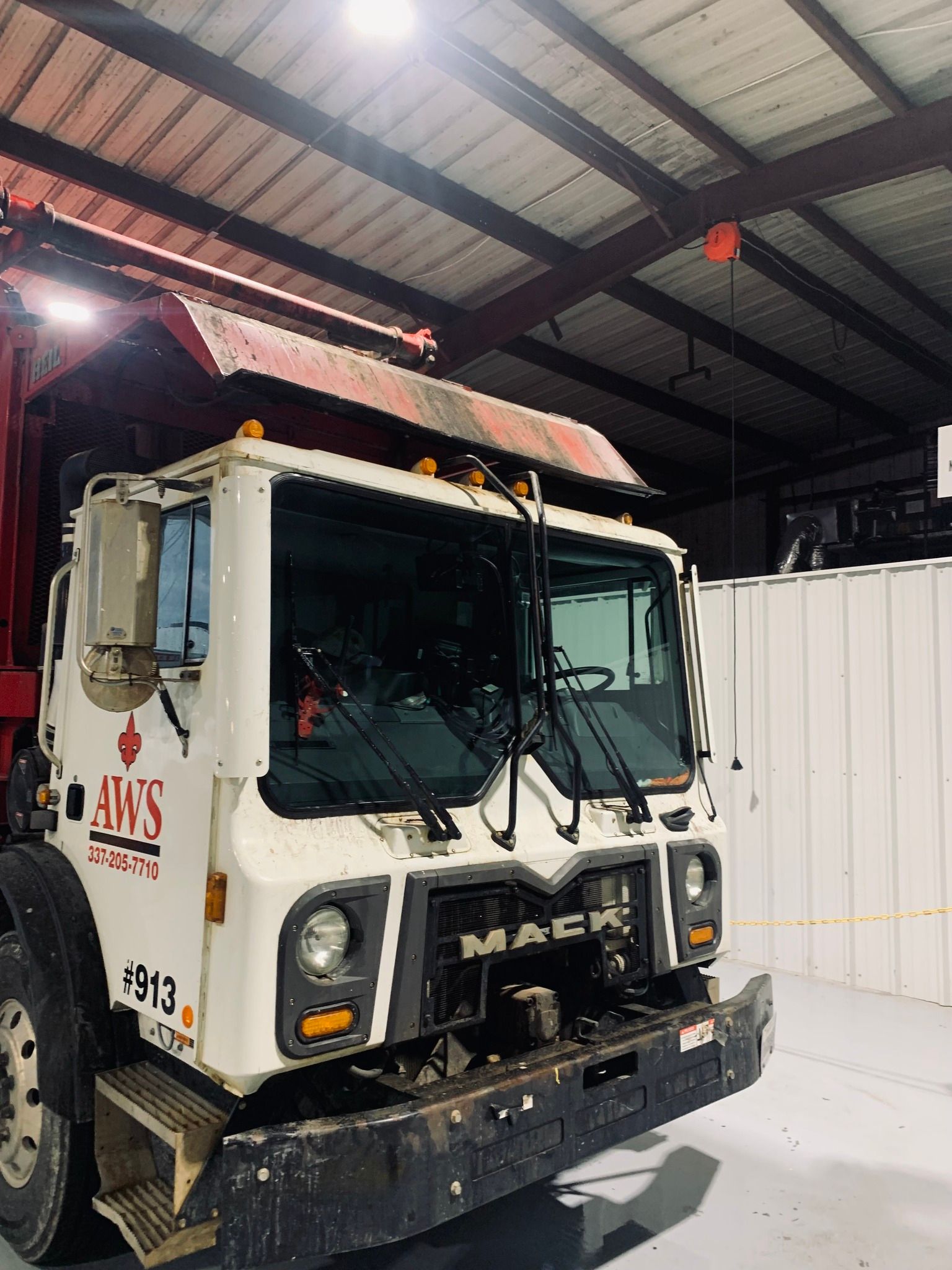A white Mack truck is parked in a warehouse