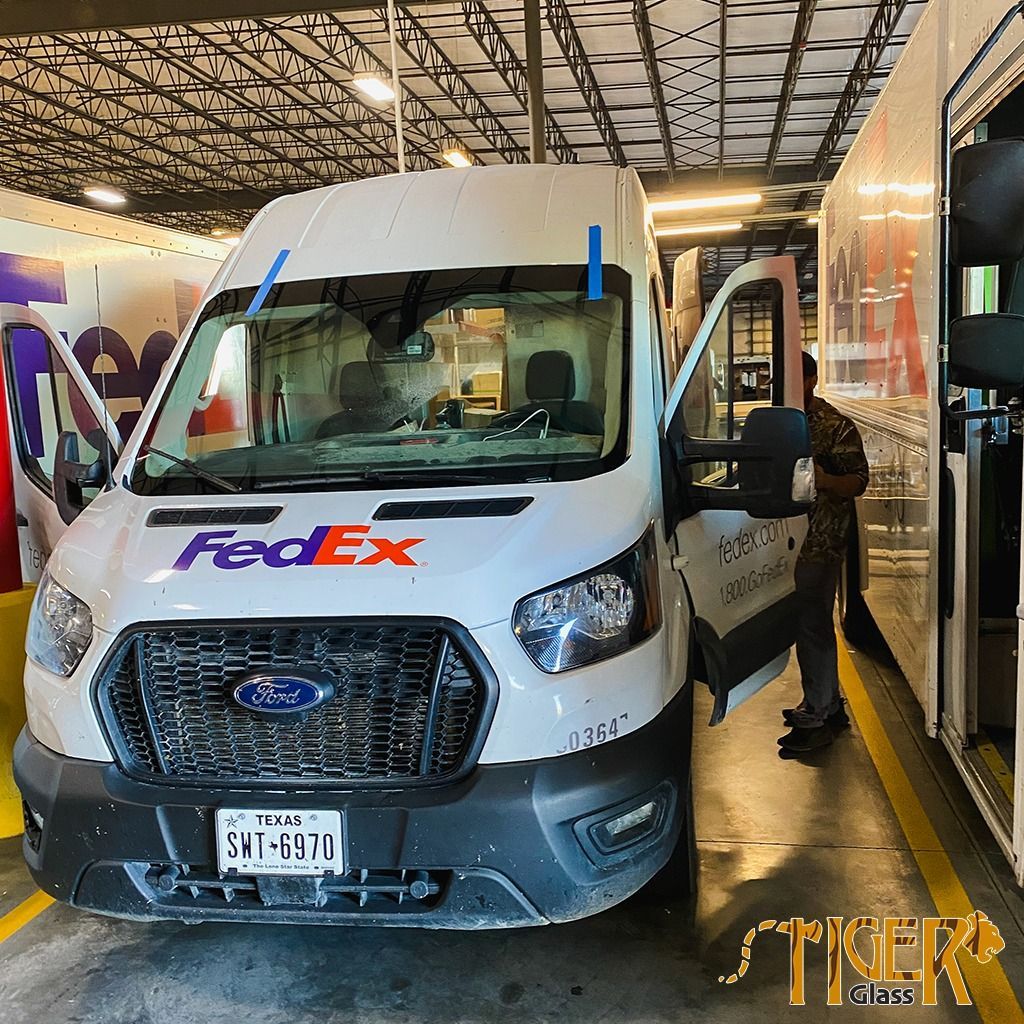 A white FedEx van is parked in a garage