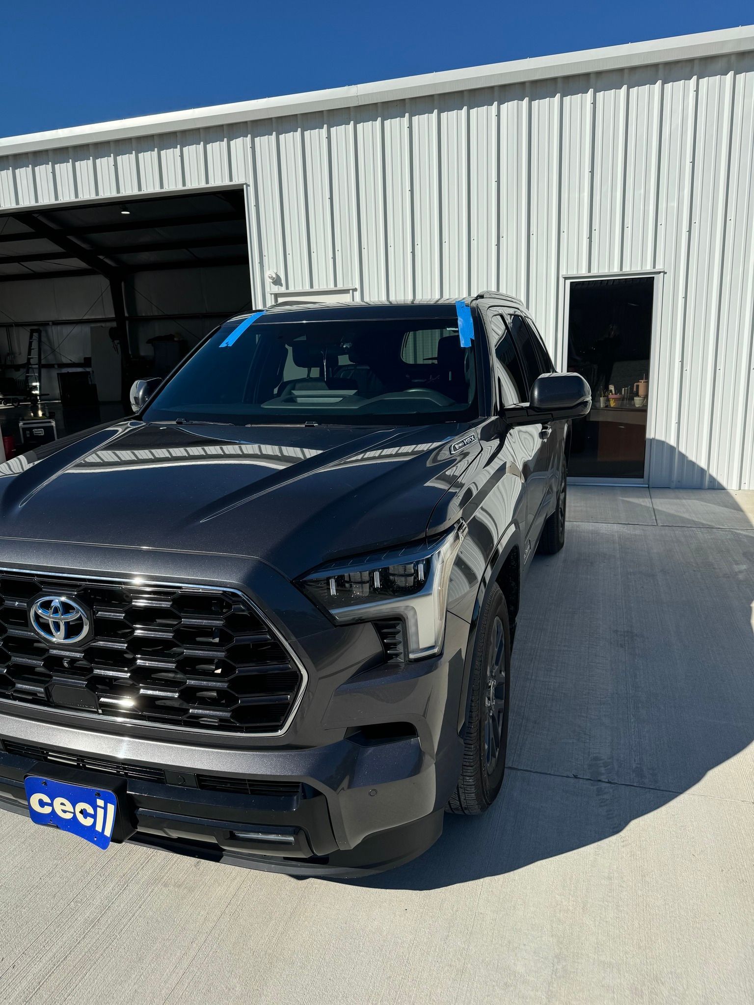 A black toyota tundra is parked in front of a white building.