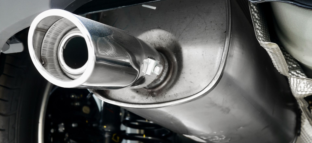 Person pouring oil into a car engine.