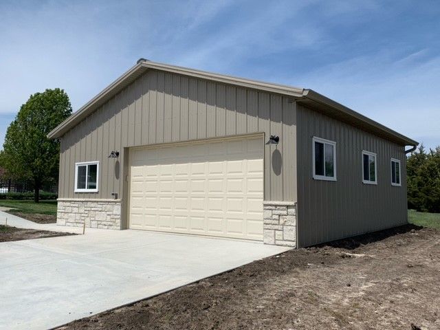 a garage with two garage doors and a driveway in front of it