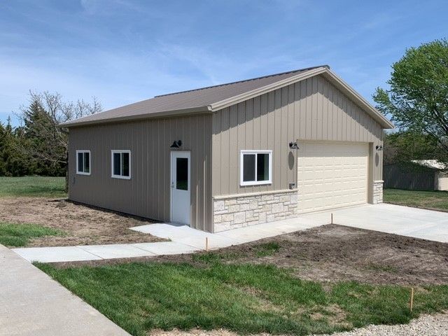 a garage with two garage doors and a walkway leading to it