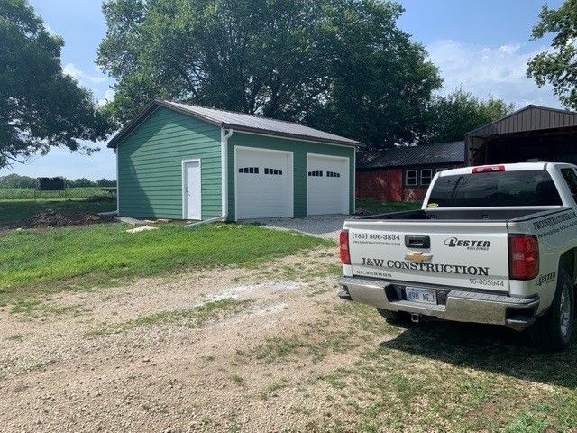 a white truck is parked in front of a green garage