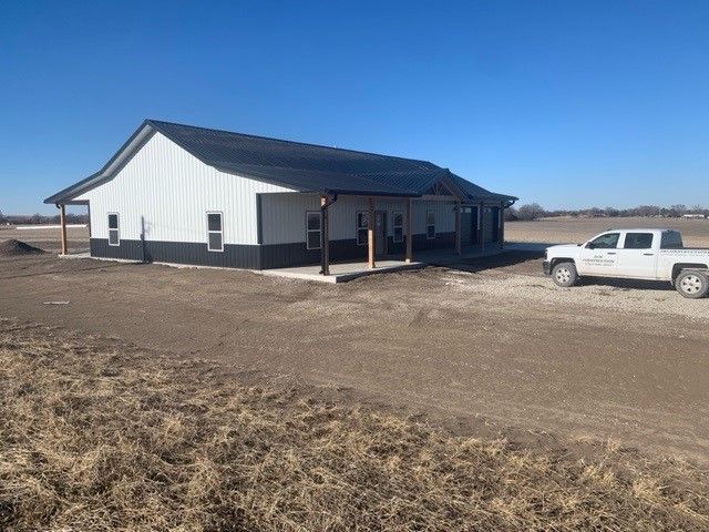 a white truck is parked in front of a house in a field