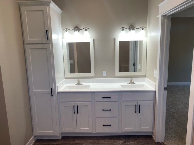 a bathroom with two sinks and two mirrors