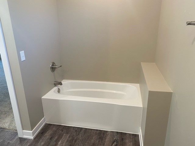 a white bathtub is in a bathroom next to a wall