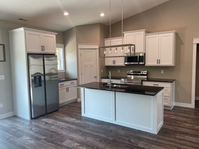 a kitchen with white cabinets and stainless steel appliances