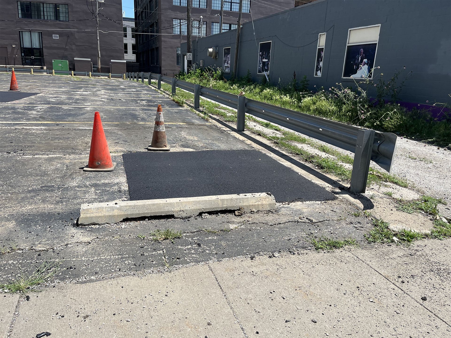 A parking lot with cones and a concrete curb