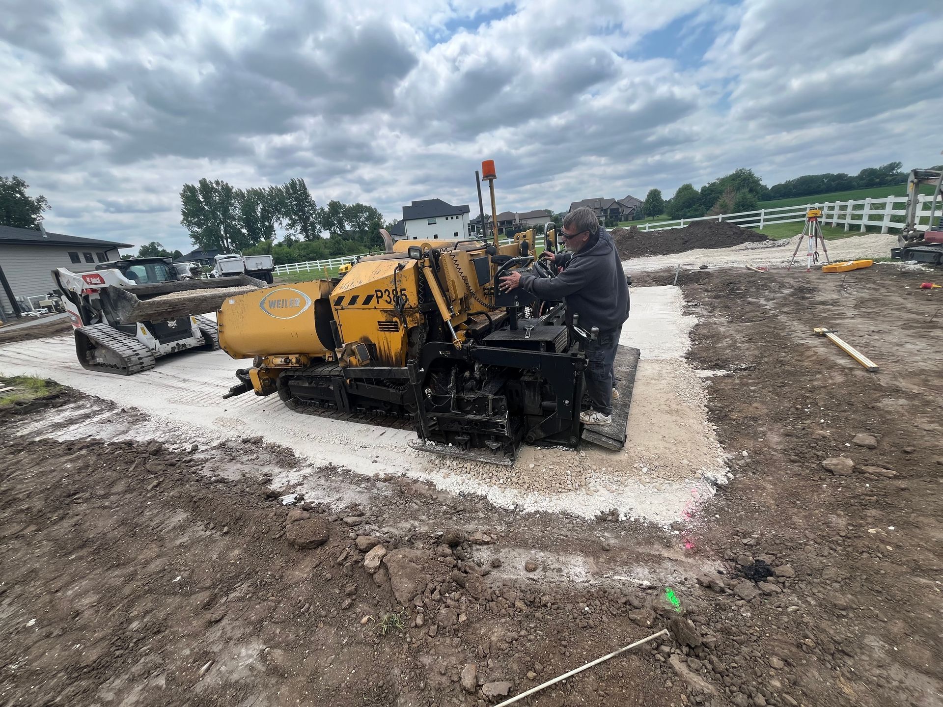 A man is operating a machine in a dirt field.