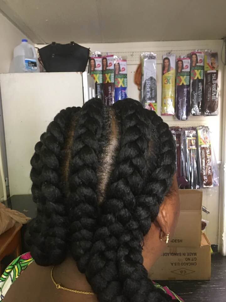 Braided hairstyle viewed from behind in a store aisle with hair products on shelves.