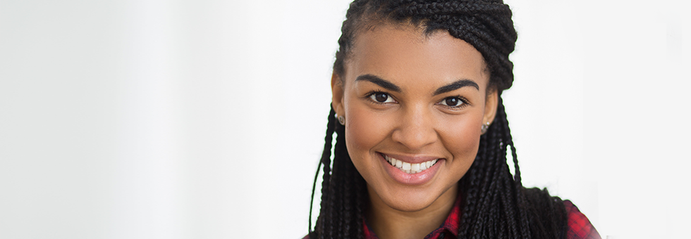 Smiling person with long braided hair.