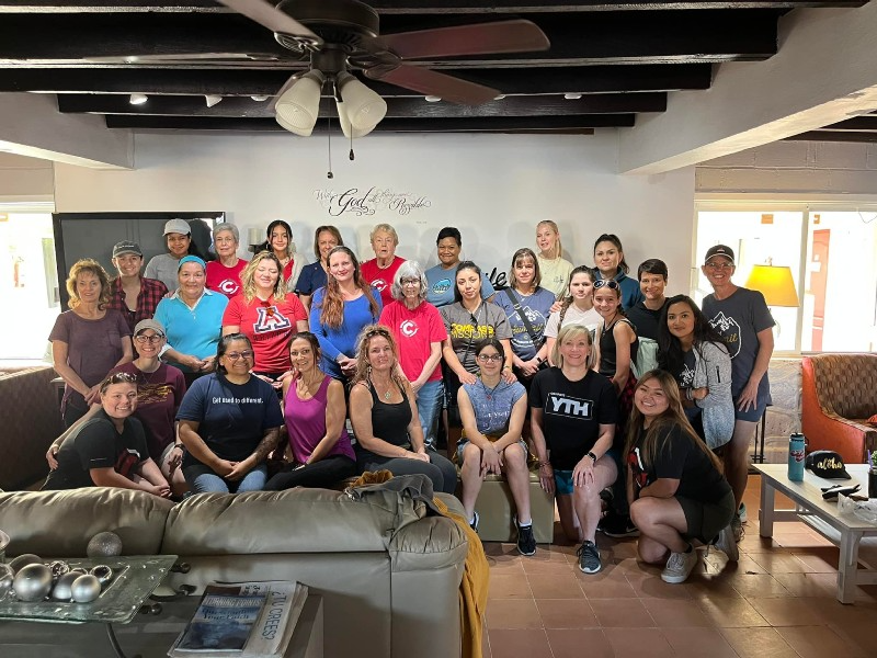 A group of people are posing for a picture in a living room.