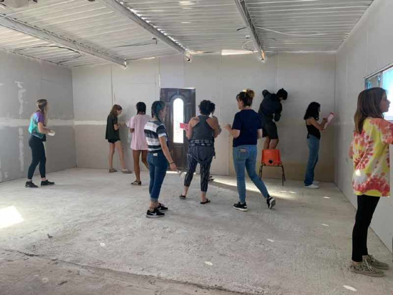 A group of people are standing in a room.