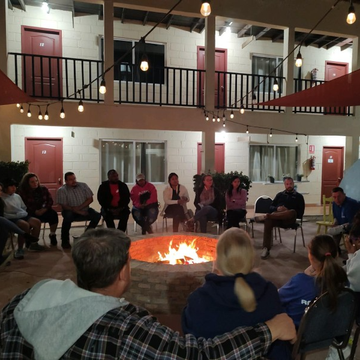 A group of people are sitting around a fire pit