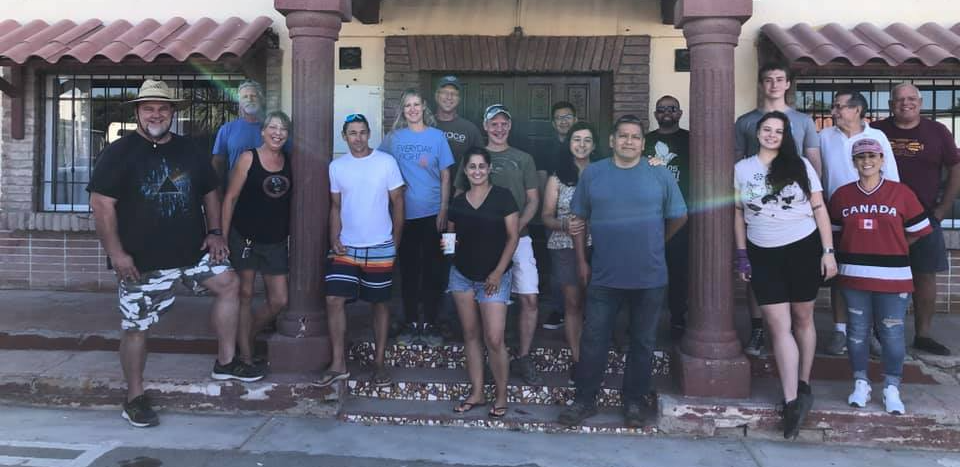A group of people are posing for a picture in front of a building.