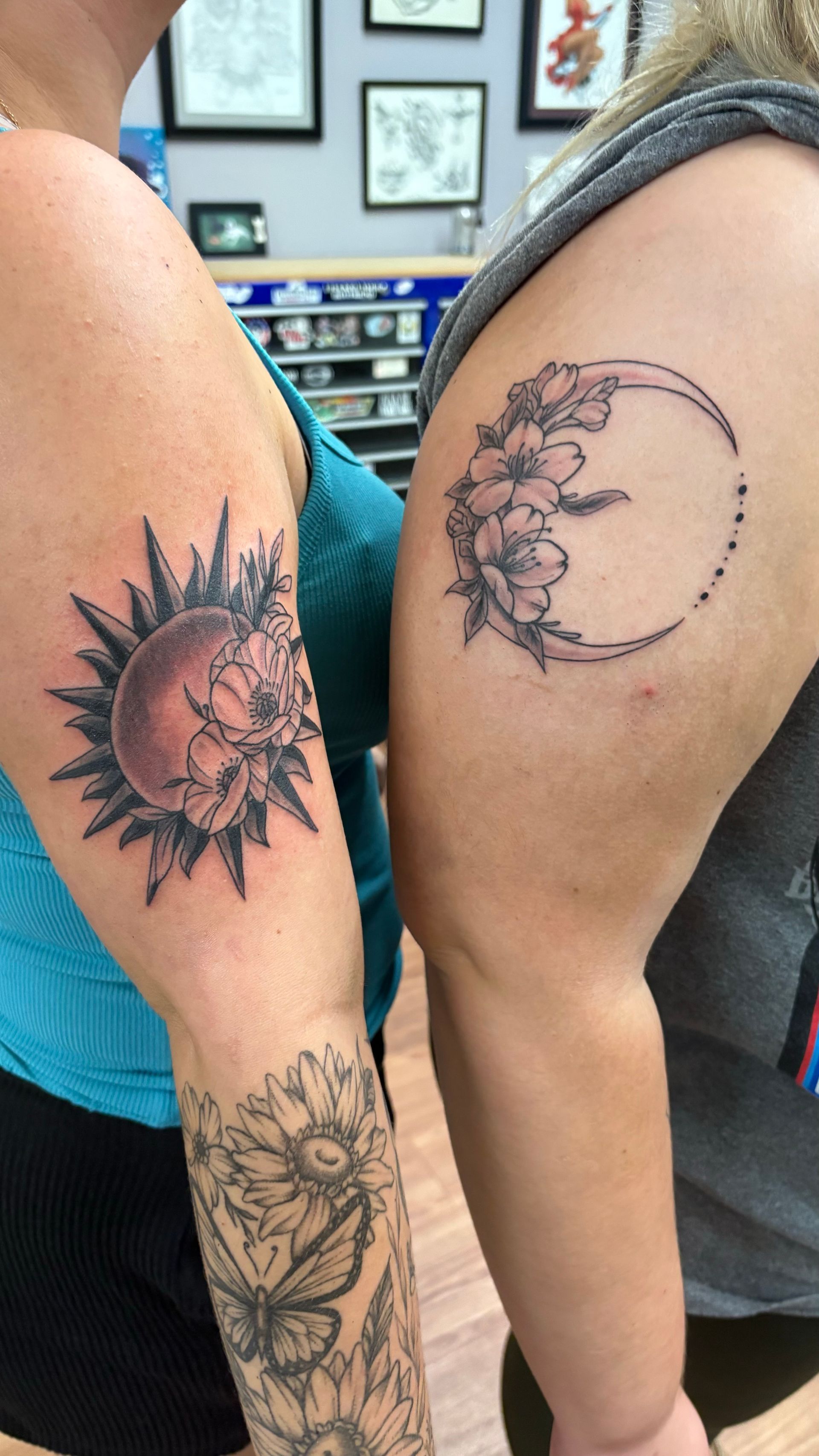 A woman has a tattoo of a sun and a crescent moon on her arm.