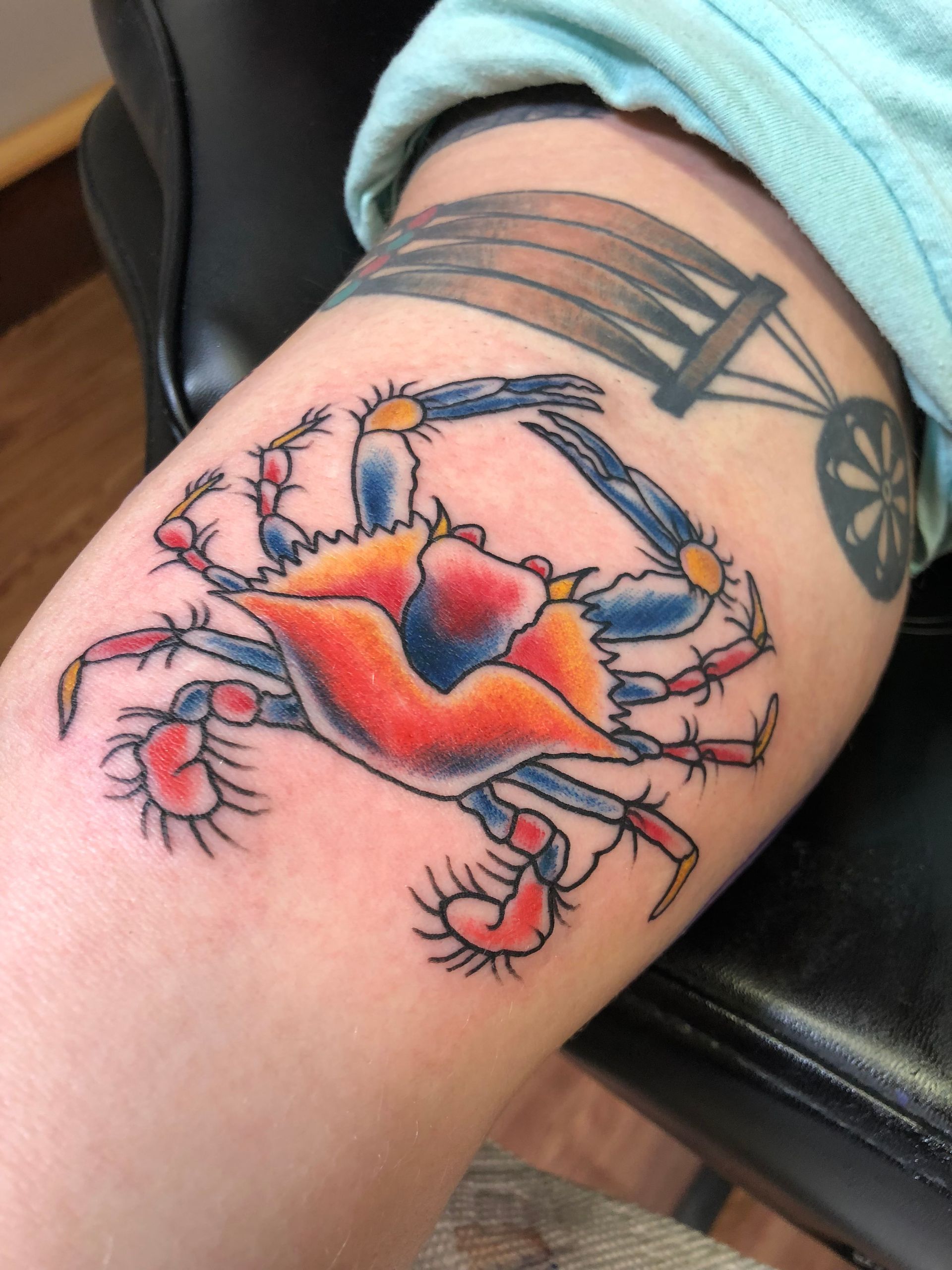 A person has a tattoo of a crab on their leg