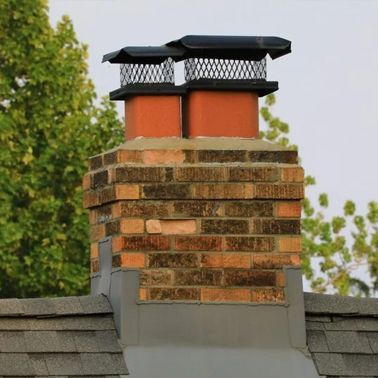 a brick chimney on top of a roof with trees in the background