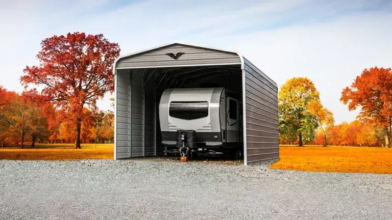 A trailer is parked inside of a metal garage.